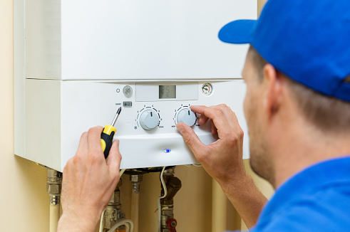 worker set up central gas heating boiler at home